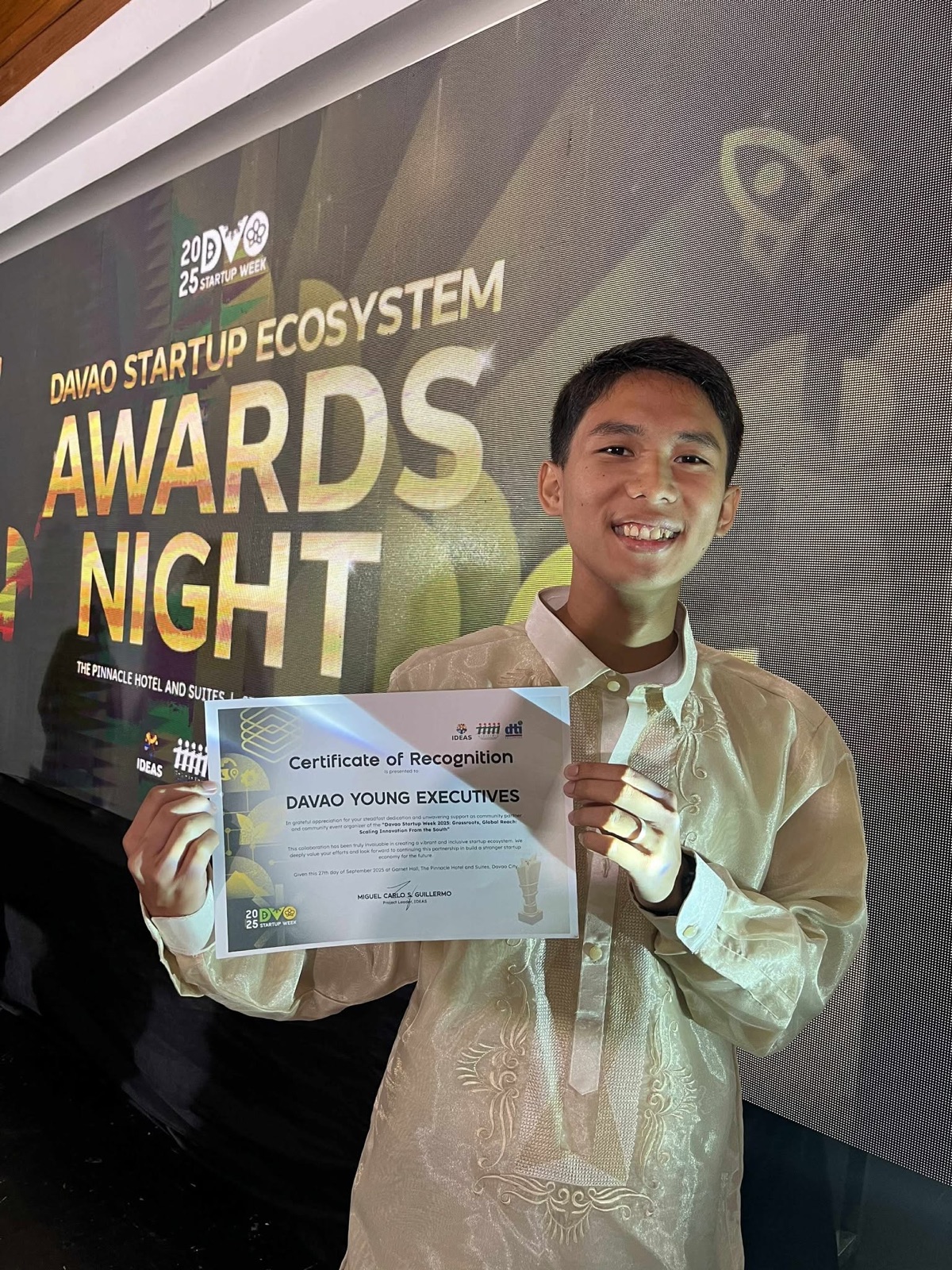 Renzo Trinidad holding a certificate of recognition at the Davao Startup Ecosystem Awards